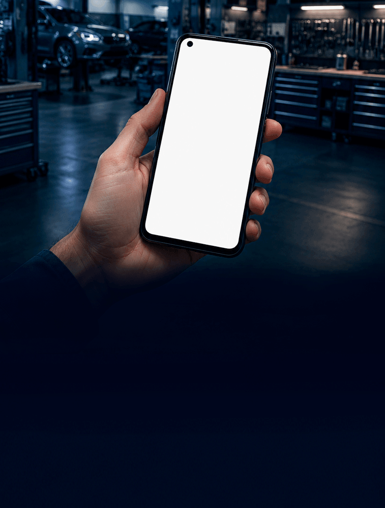 Celular nas mãos de um profissional dentro de uma oficina de funilaria organizada.